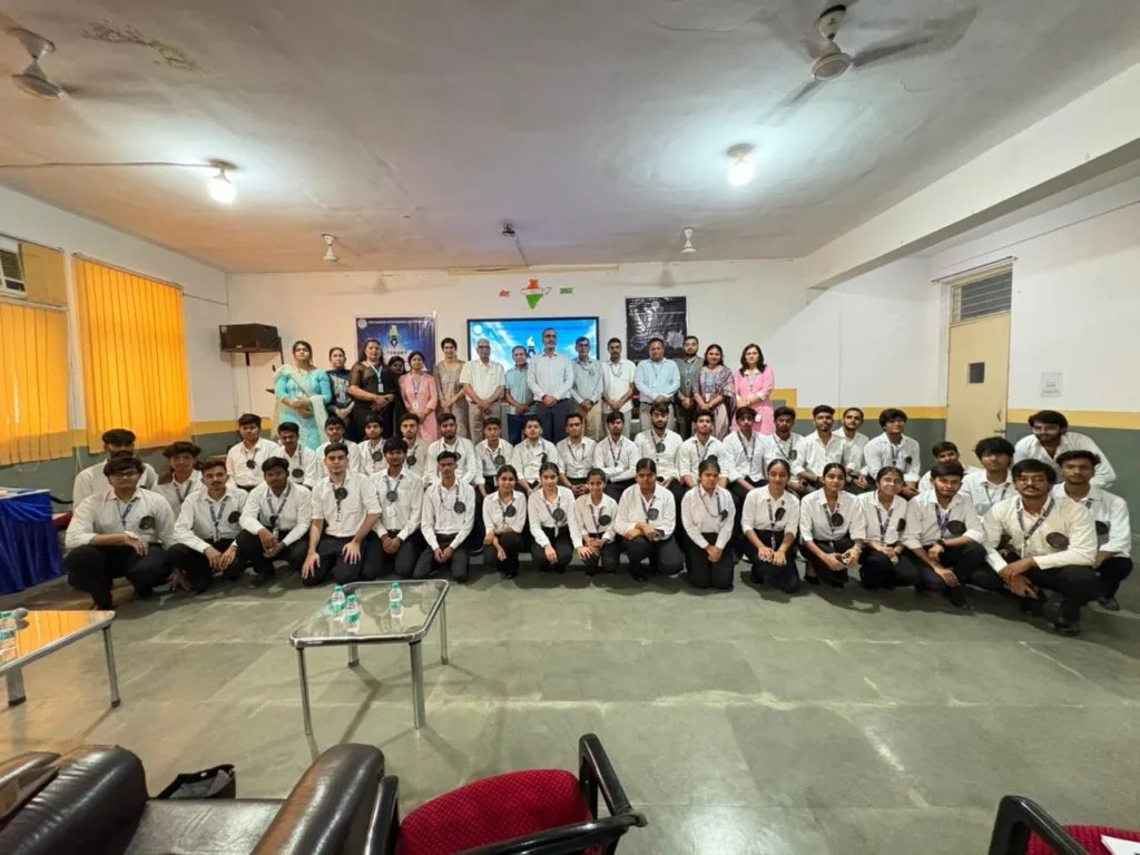 Group of students in white shirts and ties posing with teachers in a school hall for a group photo